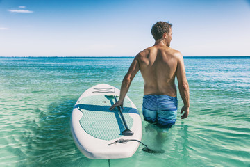 Hawaii beach fitness watersport man with SUP paddle board doing stand up paddle boarding in water.