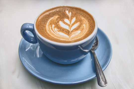 Ayurvedic Coffee Cappuccino Cup In Trendy American Cafe. Milk Foam In Rosetta Latte Art.