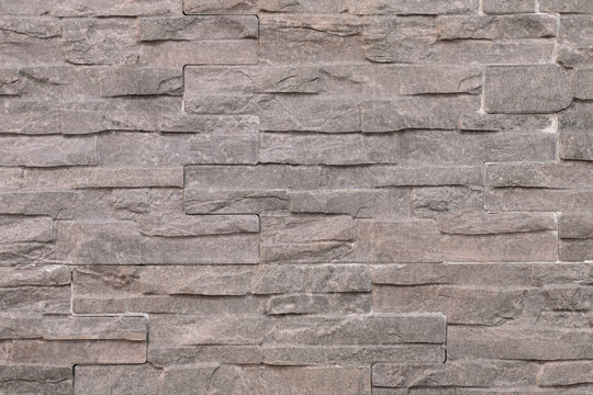 Old gray wall made of artificial stone. Abstract, modern, trendy, texture background. Design element.