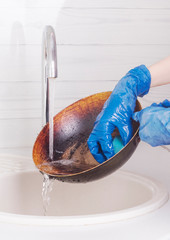 the hostess washes the pan under running water with a sponge