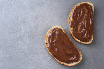 Toasts with chocolate butter on gray texture.