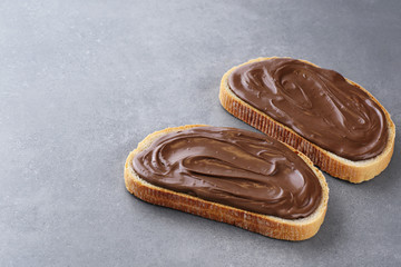 Toasts with chocolate butter on gray texture.