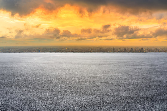 Asphalt race track ground and modern city skyline in Shanghai at sunset.
