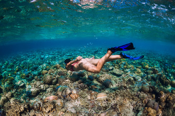 Woman freediver with fins dive underwater in the tropical sea