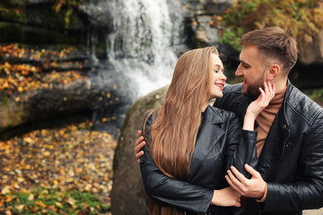 Loving young couple near waterfall