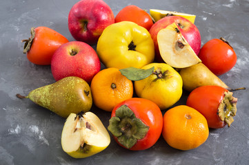 Different seasonal fruits on a concrete background. Source of vitamins and health. Healthy eating concept.
