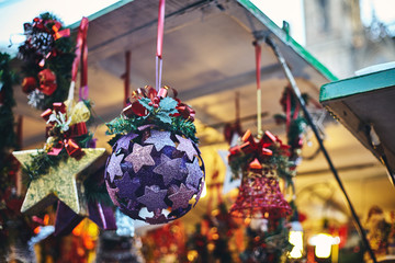 decoration in the form of a large shiny purple ball with a red bow. shot close-up on a blurry background. Christmas market