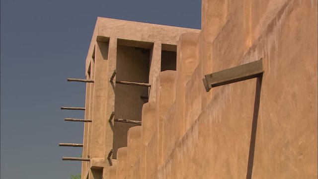 Extreme close-up low angle still shot against the blue sky of a wind tower or wind catcher of a traditional building. The tower openings allowed for air movements through buildings for effective