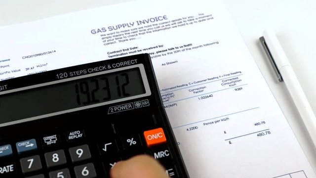Communal payments. Check Gas supply invoice. Human makes a calculation on a calculator and checks the gas bill. Close-up