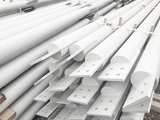 White colored stacked metal diagonal bracings with holes for bolts.