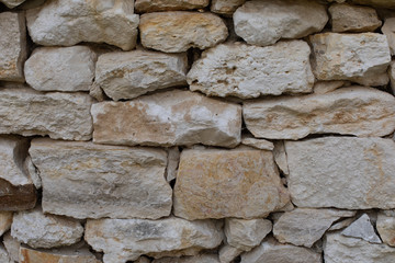 Limestone brick, masonry wall, rough uneven pieces of sandstone, backdrop texture background. White gray textured surface of limestone