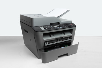 A multi function printer, copier, scanner on office table. gray wall behind  - Image
