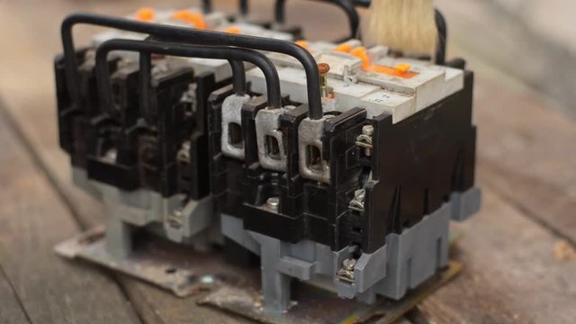  Close-up of a used electric starter (magnetic starter). Brush dust and dirt before scheduled maintenance. An electromagnetic device for smoothly starting high-power electric motors. Side view. 