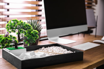 Modern workplace with beautiful miniature zen garden and computer in room