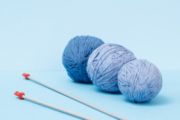 Woolen yarn for knitting. Balls of natural wool yarn and knitting needles