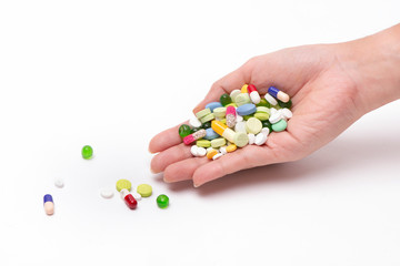Close – up medicine on hand.A woman holding lots of pills and medicine.They are on pill background.