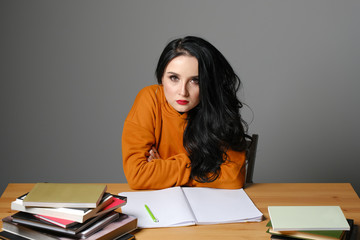 young woman is sitting at the books. education
