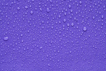 Water drops on lilac background, top view