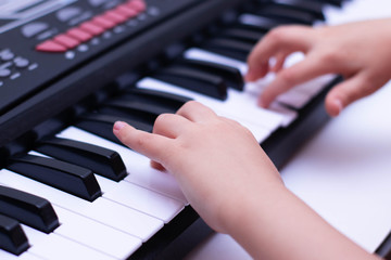 Fototapeta premium Children's hands play the keys of the piano. Learning music.