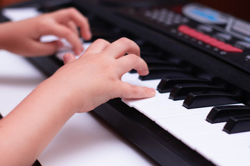 Obraz premium Children's hands play the keys of the piano. Learning music.