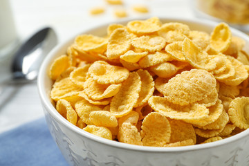 Tasty corn flakes on white table, closeup