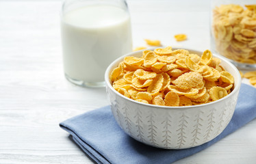 Tasty corn flakes on white wooden table