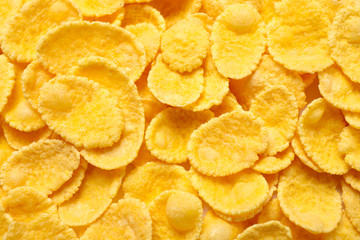 Tasty crispy corn flakes as background, top view