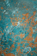 Vertical photo of a corroded old abandoned rusty sheet of iron with peeling cracked damaged blue paint. Trendy, modern, abstract, grunge, texture background.