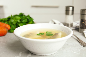 Delicious fish soup served on marble table