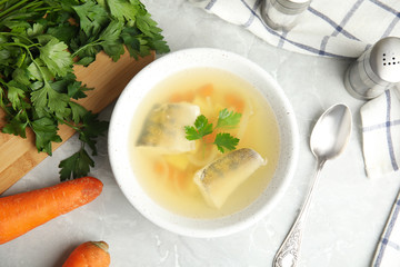 Delicious fish soup served on marble table, flat lay