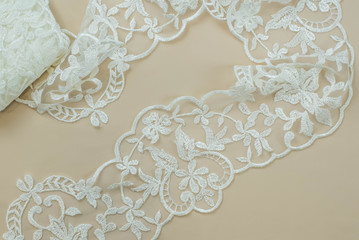 Texture lace fabric. lace on white background studio. thin fabric made of yarn or thread. a background image of ivory-colored lace cloth. White lace on beige background.