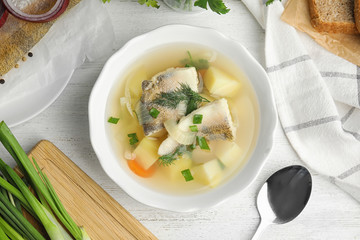 Delicious fish soup served on white wooden table, flat lay