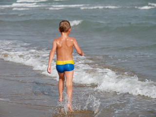 Children swim in the sea on the beach in Bibione, Italy