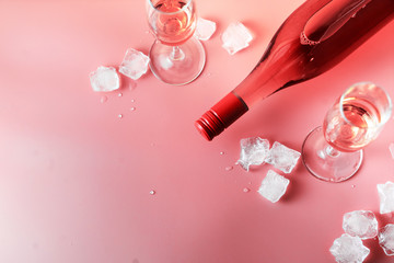 Holiday celebration. Pink champagne and an ice glass with champagne glasses wedding. Pink background with copy space.