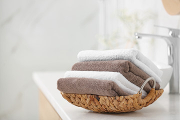 Basket with clean towels on counter in bathroom