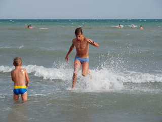 Children swim in the sea on the beach in Bibione, Italy