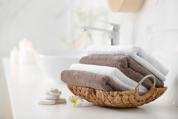 Basket with clean towels on counter in bathroom - obrazy, fototapety, plakaty
