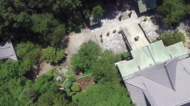 Flying by drone over a Tokio tempel  at a summer day.