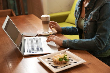 Fototapeta na wymiar Blogger working with laptop in cafe, closeup