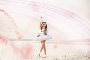 Tender young ballerina dancer in a snow-white tutu dress and white pointe shoes in pink smoke.  on a salty dried lake. Fantastic landscape and a girl  ballerina © Ann Stryzhekin