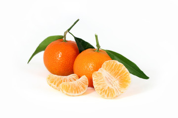 Three fresh clementines with green leaves and juicy slices isolated on white background  
