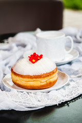 White flower doughnut with glass and lace on the table