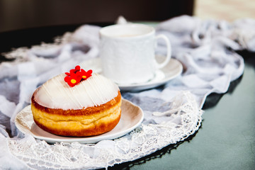 White flower doughnut with glass and lace on the table