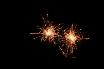 Two sparklers firework on black background. Christmas celebration.