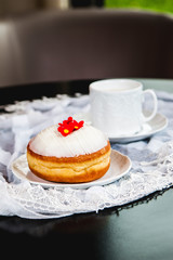 White flower doughnut with glass and lace on the table