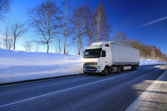 White truck transport on the road and cargo in winter