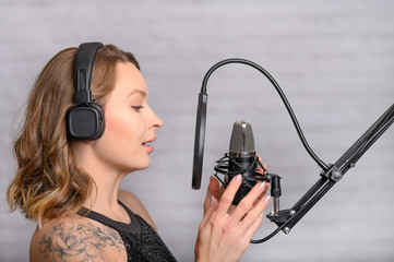 Recording a speech on a radio station, announcer, or singer, blogger works in the studio with a...