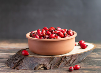 Clay bowl with rosehip fruits, rich in vitamin C, immunity protection and antioxidant. Copy space