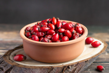 Rosehip fruits in clay bowl, rich in vitamin C, immunity protection and antioxidant