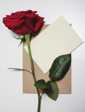 Elegant Colombian Rose Over A Valentines Day Greeting Card Letter Mockup And A Kraft Envelope, With Copy Space.